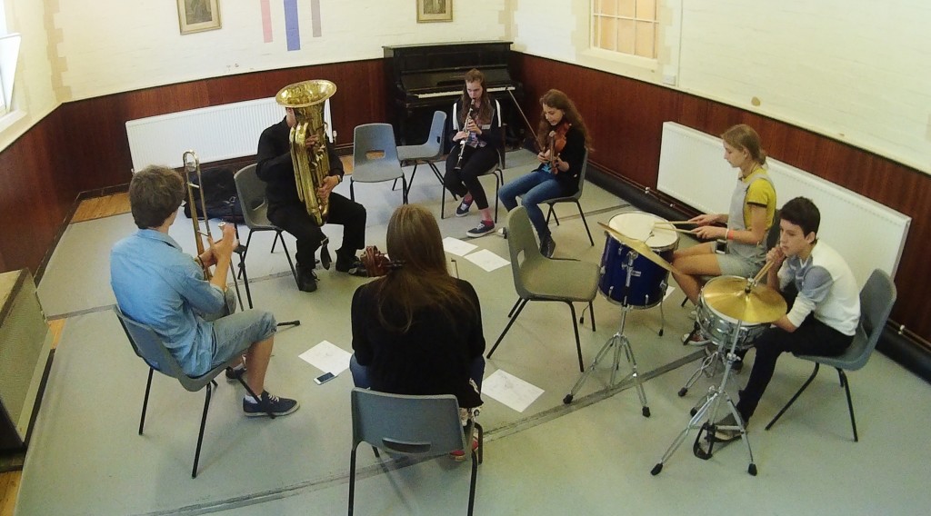 Seven musicians learning improvisation on various instruments.