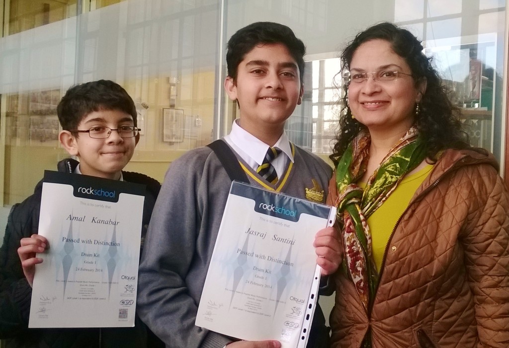 Students and family with Rockschool certificates.