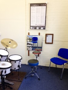Aquarian practice pad, wall-mounted mirror and drum rudiment chart set up in Studio 1.